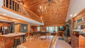 A spacious kitchen with a large island, wooden ceiling, and a stone fireplace. - Enjoy Adventure & Relaxation w/ Hot Tub & Fire Pit (McHenry)