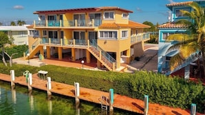 A two-story building with balconies, a pool, and a clear view of the sky. - P21  - Charming 3 bedroom 3.5 bath duplex with dockage and Cabana Club. (Key Colony Beach)