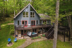 Une cabane à deux étages dotée d’une terrasse, de meubles de jardin et d’un bain à remous.