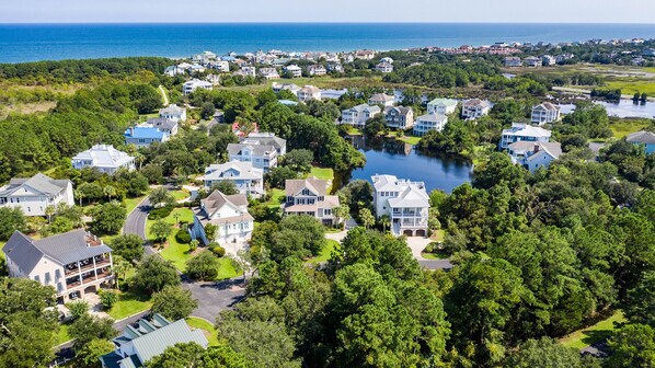 A residential area with houses, a lake, and a view of the ocean.