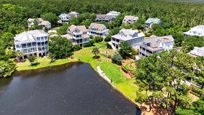 A residential area with multiple houses, a lake, and a well-maintained lawn. - Inviting Beach Retreat with wonderful Lake Views to Relax and Enjoy (Georgetown)
