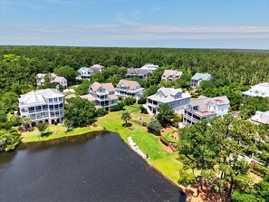 A residential area with multiple houses, a lake, and a well-maintained lawn.