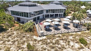 A modern building with a glass facade, outdoor seating area, and a covered patio. - Inviting Beach Retreat with wonderful Lake Views to Relax and Enjoy (Georgetown)