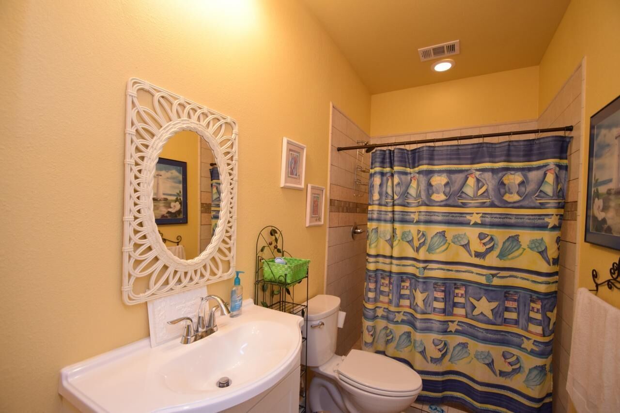 A bathroom with a sink, toilet, and shower curtain.