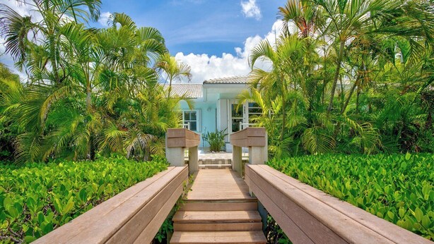 A wooden pathway leading to a building with a tiled roof, surrounded by lush greenery. - P27 - Private Beach Access! Pool home with everything you need for an unforgettable vacation. 3 bedroom 2 baths with deep water dockage. (Key Colony Beach)