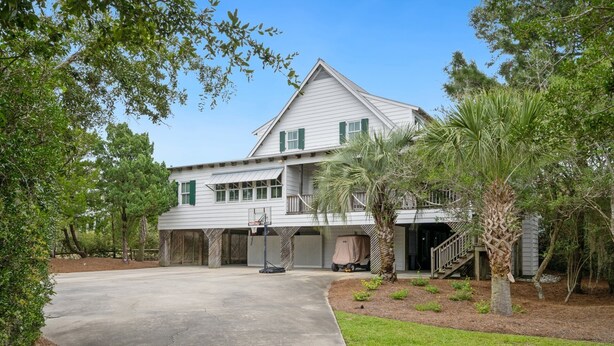 Une maison à deux étages avec une allée couverte et un panier de basketball.