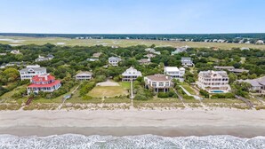 An aerial view of a coastal residential area with houses, a beach, and a golf course. - Spectacular Oceanfront Living with an Inviting Kitchen Perfect for Entertaining Kitchens Beach House (Georgetown)