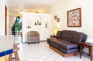 Relax in this stylish living room with a sofa, armchair, and dining table.