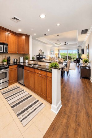 A spacious kitchen with wooden cabinets, a central island, and a dining area with a view.