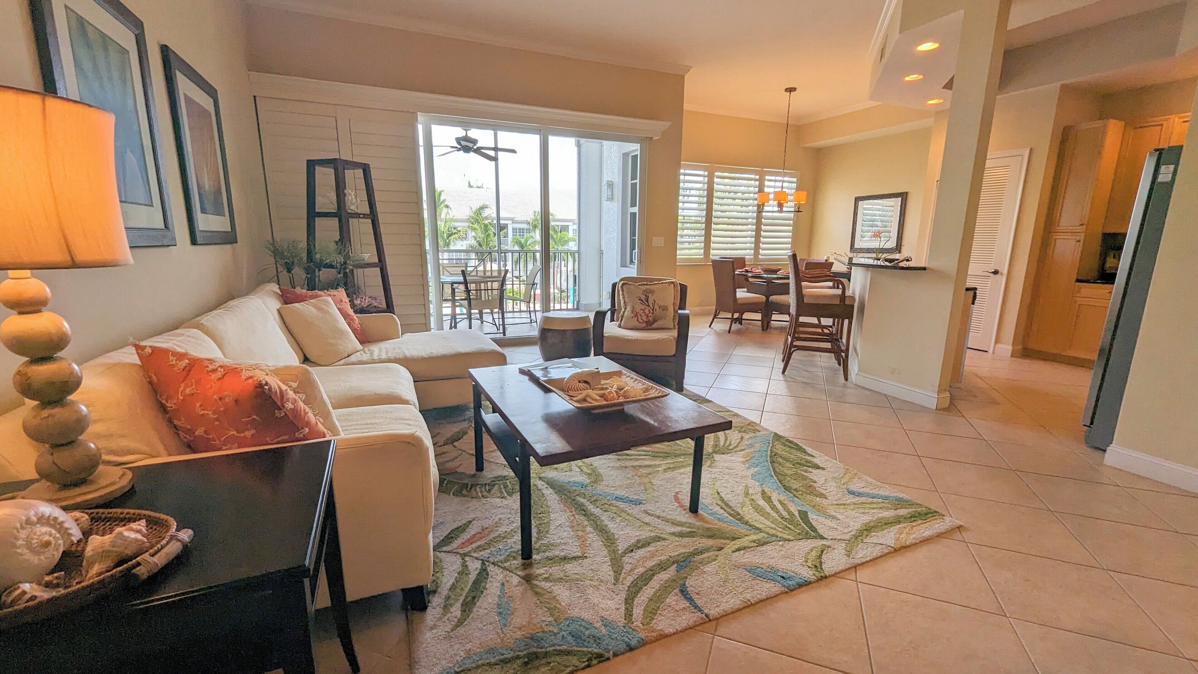 A spacious living room with a sofa, coffee table, and dining area.