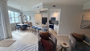 A modern living room with a dining area, kitchen, and a view of the city. - Relax In This Poolside Paradise! (Bonita Springs)