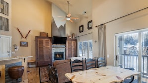 Un comedor acogedor con una mesa de madera grande, sillas y una chimenea.