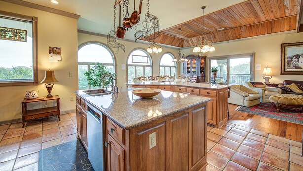 A spacious kitchen with a large island, wooden cabinets, and a view to the outdoors. - Second Row, Steps away from the Ocean, Pool Table, Large Sun Deck (Georgetown)