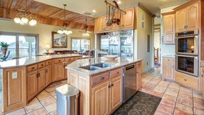 A spacious kitchen with wooden cabinets, granite countertops, a double sink, and stainless steel appliances. - Second Row, Steps away from the Ocean, Pool Table, Large Sun Deck (Georgetown)