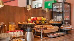 A breakfast buffet with various food items, including fruits, pastries, and cereals. - B&B Hotel Treviso (Treviso)