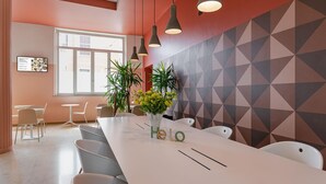 A conference room with a long table, chairs, pendant lights, and a geometric-patterned wall. - B&B Hotel Treviso (Treviso)