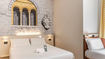 Camera d'albergo con un letto grande, una parete in mattoni con un arco decorativo e una testiera con illuminazione integrata.