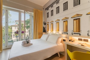 A hotel room with a bed, a desk, and a view of the outside. - B&B Hotel Treviso (Treviso)