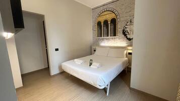 A bedroom with a single bed, a wall-mounted TV, and a mural.