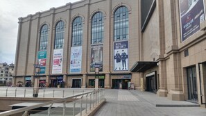 A large building with multiple large windows and several banners advertising various brands and products. - Ramada Plaza Dongxing City Center (Fangchenggang)