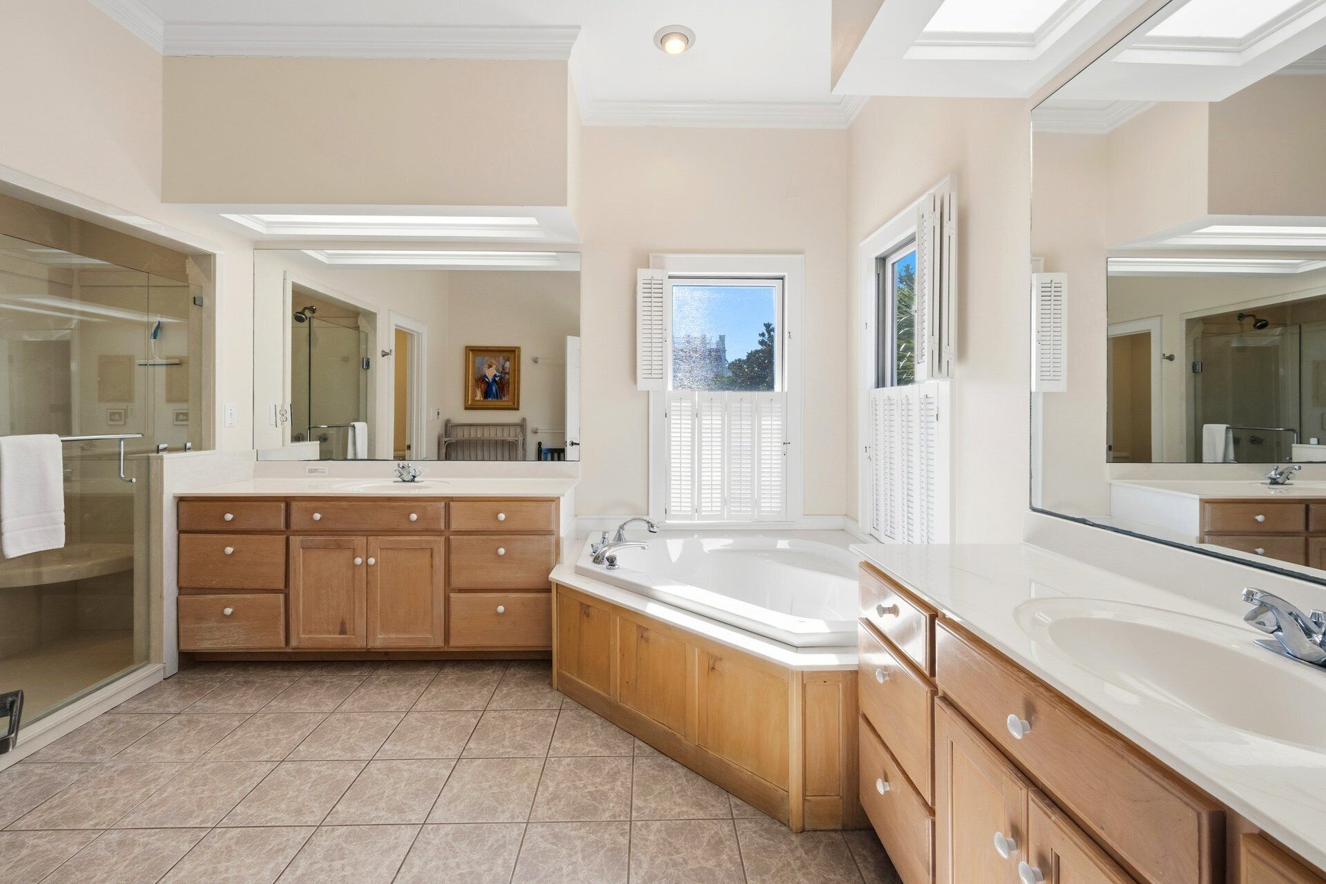 A spacious bathroom with a large vanity, a bathtub, and a walk-in shower.