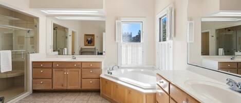 A spacious bathroom with a large vanity, a bathtub, and a walk-in shower.