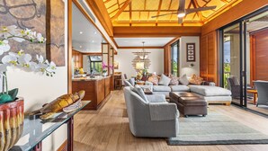 A spacious living area with a high ceiling, a glass coffee table, and a comfortable seating arrangement. - Top-Floor breathtaking views, close to beach! (Kamuela)
