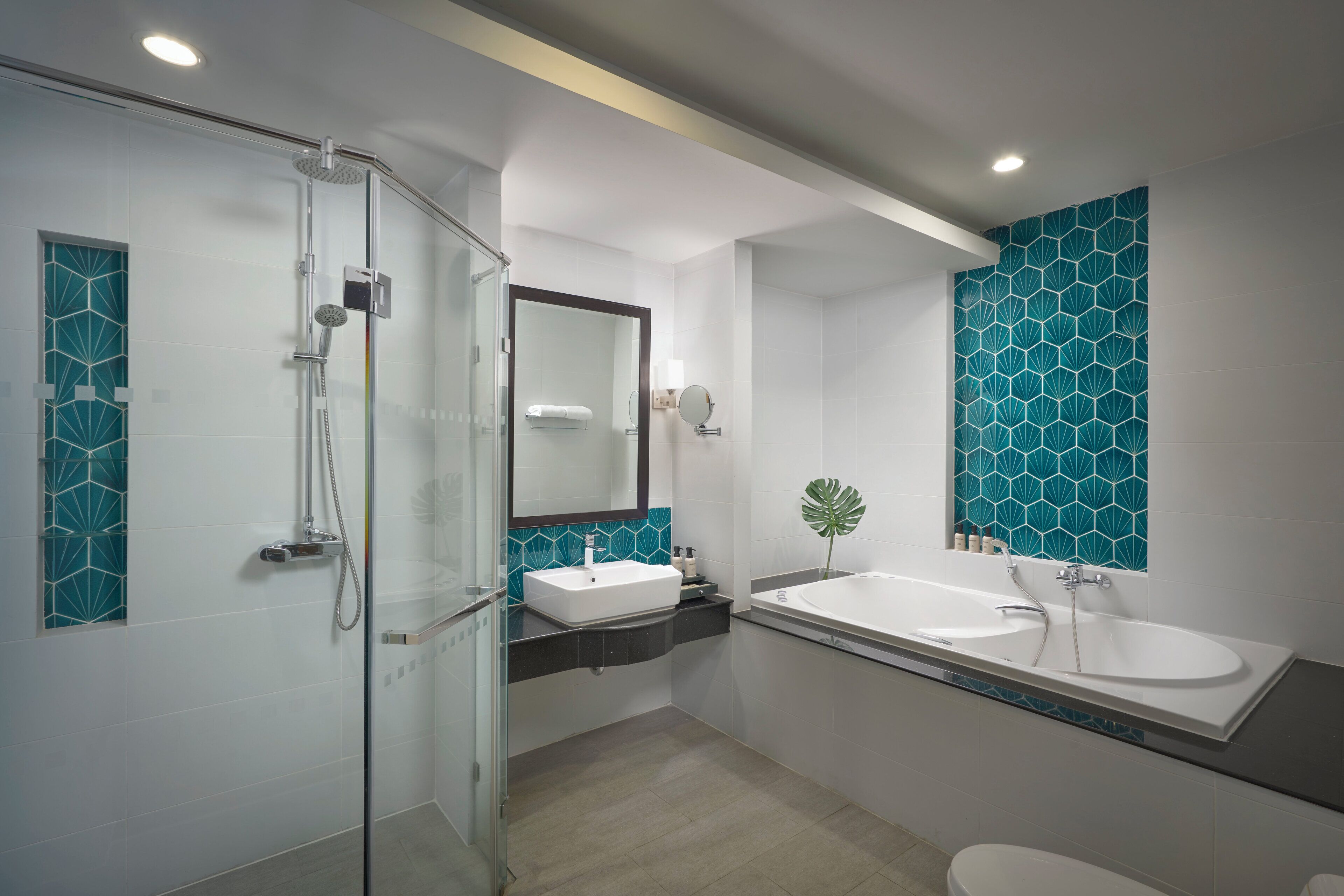 Un baño moderno con cabina de ducha de vidrio, lavamanos blanco y un espejo grande.