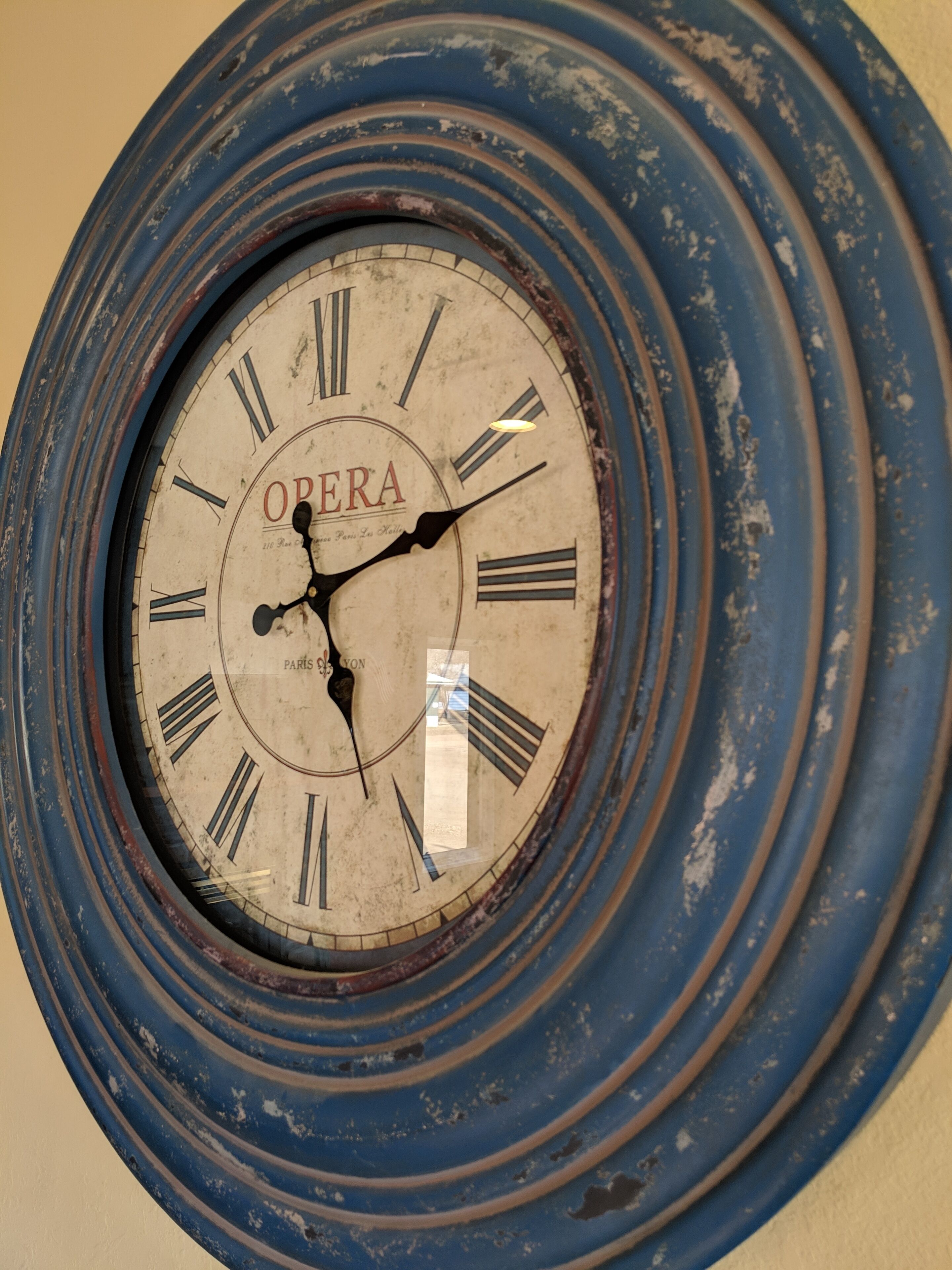 Un reloj de pared con diseño vintage, que muestra números romanos y el nombre de la marca 'ORERA'.