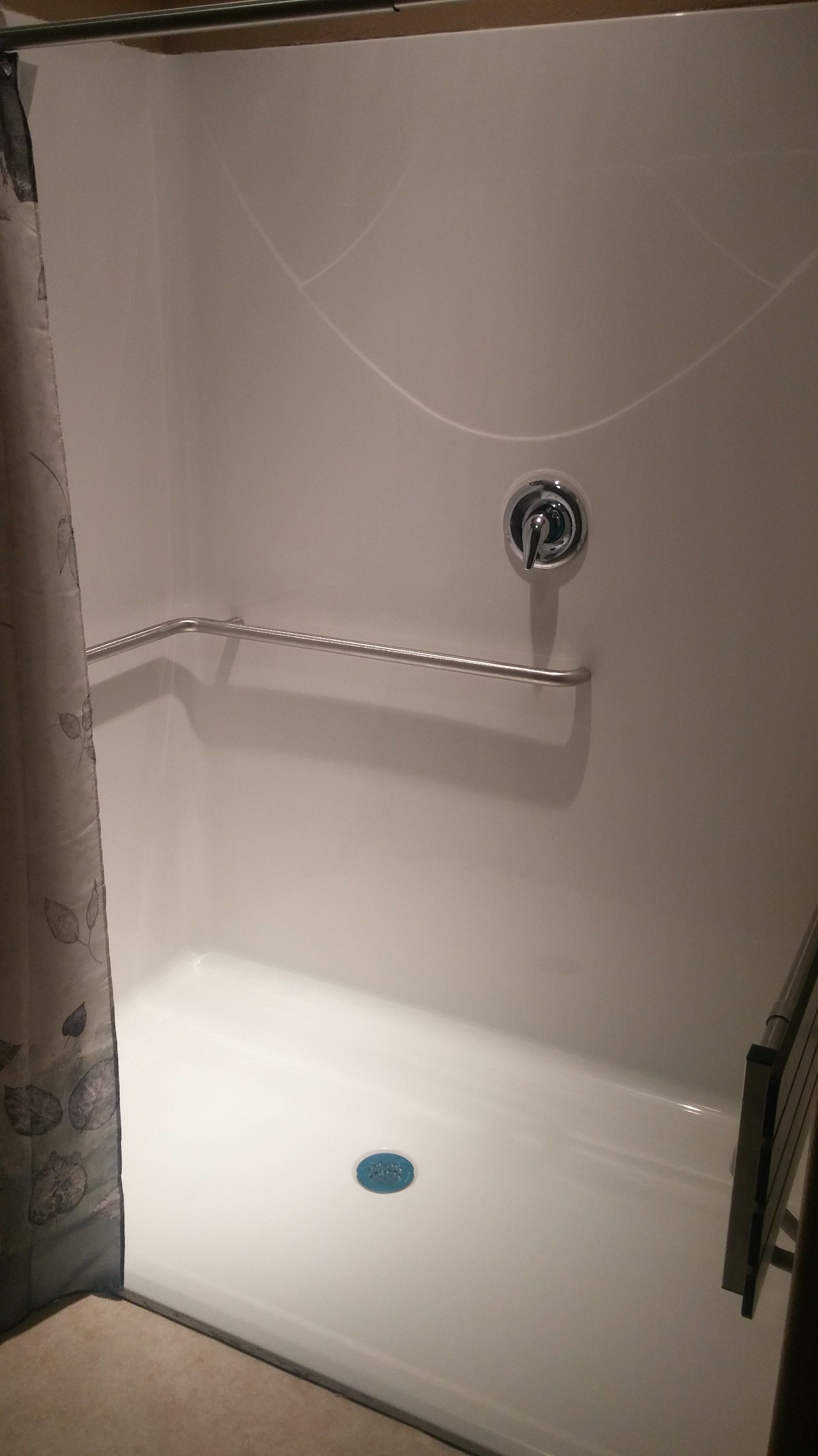 A white bathtub with a chrome faucet and a blue drain.