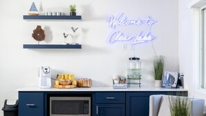 A modern kitchen with a neon sign, a coffee maker, and various kitchen utensils. - Lakeside Inn (Clear Lake)