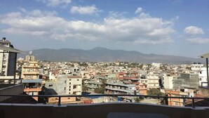A cityscape with a view of mountains in the distance. - Bliss Apartment (Kathmandu)