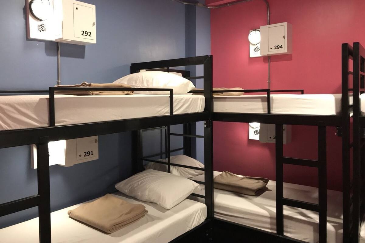 Une chambre avec des lits superposés, comprenant trois lits, chacun étant muni d’une étiquette numérotée.