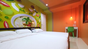 Une chambre d’hôtel avec un grand lit, un bureau avec une chaise et une fresque murale.