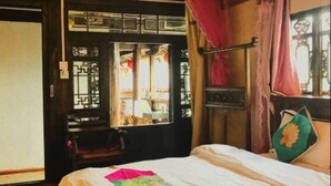 A bedroom with a bed, a window with curtains, and a door. - Lijiang Shanju Zuihuayin Inn (Lijiang)