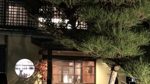 A traditional Japanese building with a wooden gate, a small circular window, and a staircase leading to the entrance. - Tabino Hotel Hida - Takayama (Takayama)