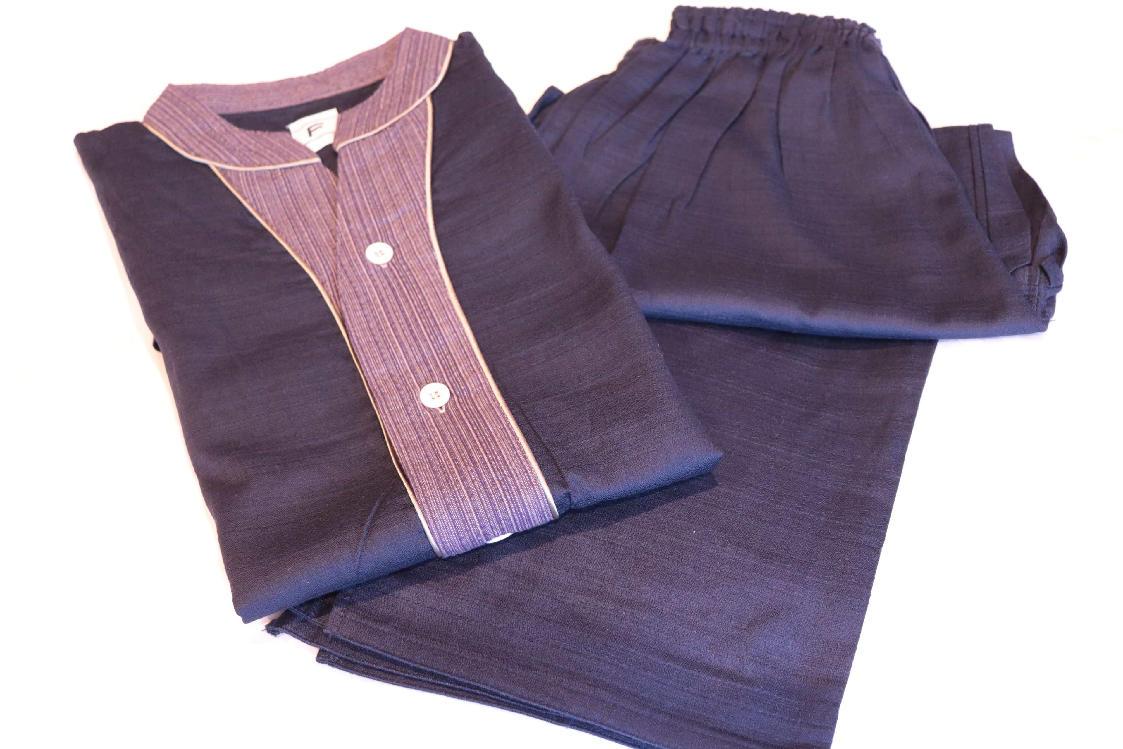 A neatly folded dark-colored shirt with a collar and buttons.