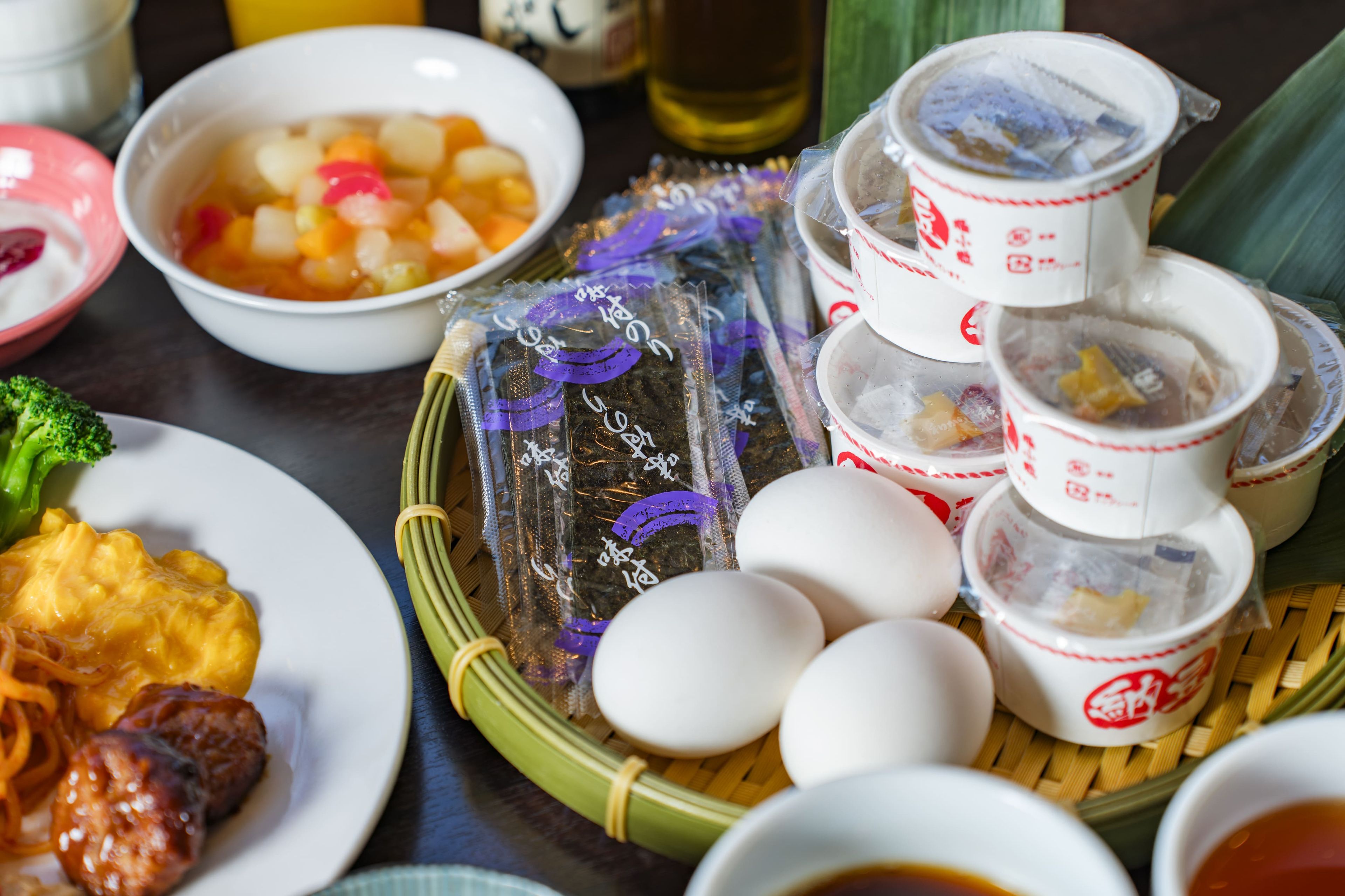 Una mesa con varios platos, incluyendo un tazón de sopa, un plato de carne y varias tazas de té.