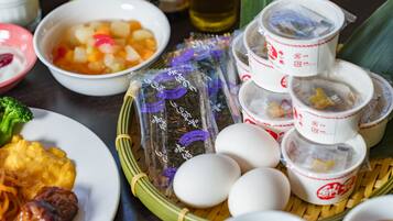 A table with various dishes, including a bowl of soup, a plate of meat, and several cups of tea.