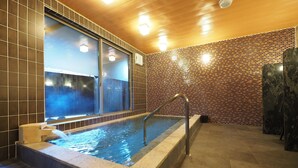 A spa area with a hot tub, tiled walls, and a wooden ceiling. - Tabino Hotel Hida - Takayama (Takayama)