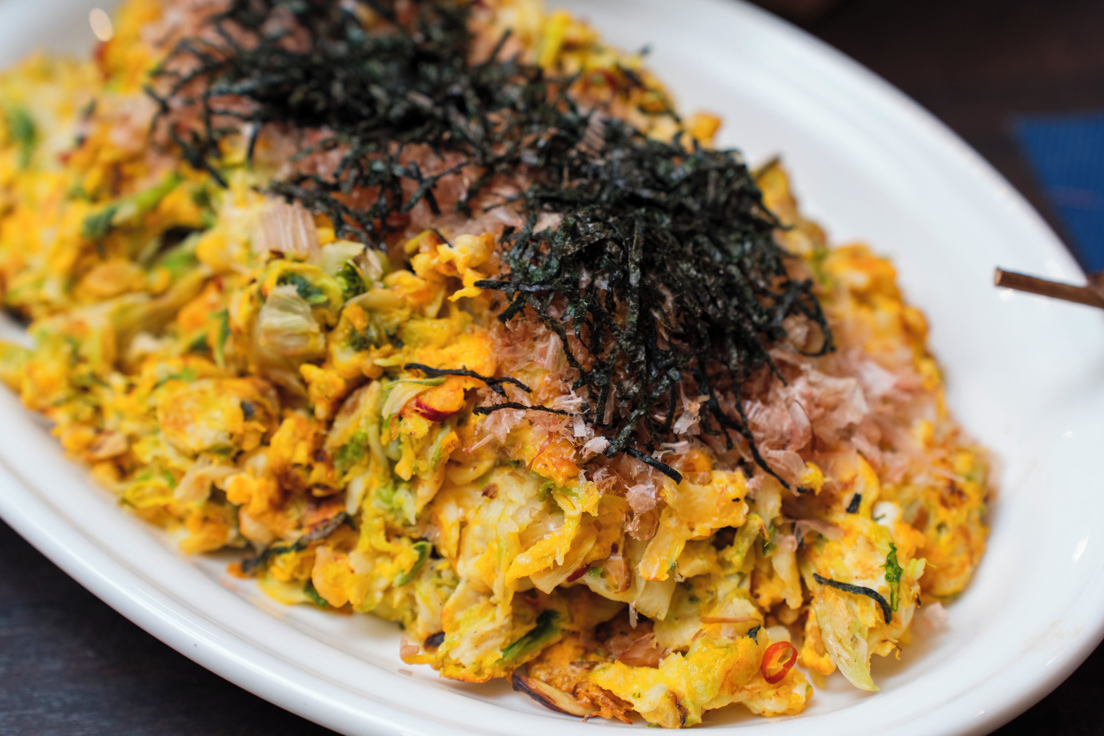A plate of food with various ingredients, including shredded toppings.