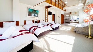 A hotel room with a large bed, a desk, and a view of the kitchen. - Petit Hotel P-Bow (Hakuba)
