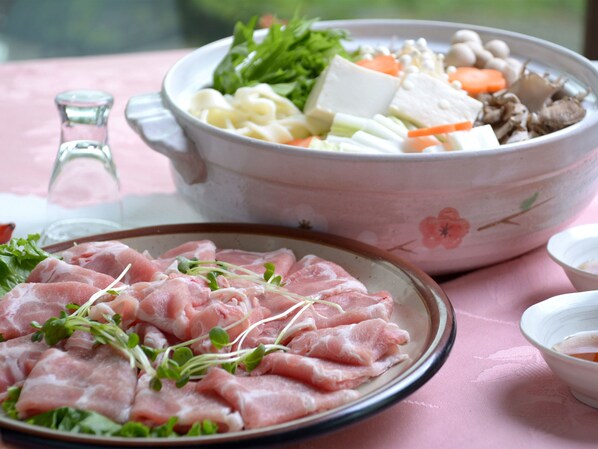 A table with a bowl of food, a plate of meat, and a glass of water. - Petit Hotel P-Bow (Hakuba)