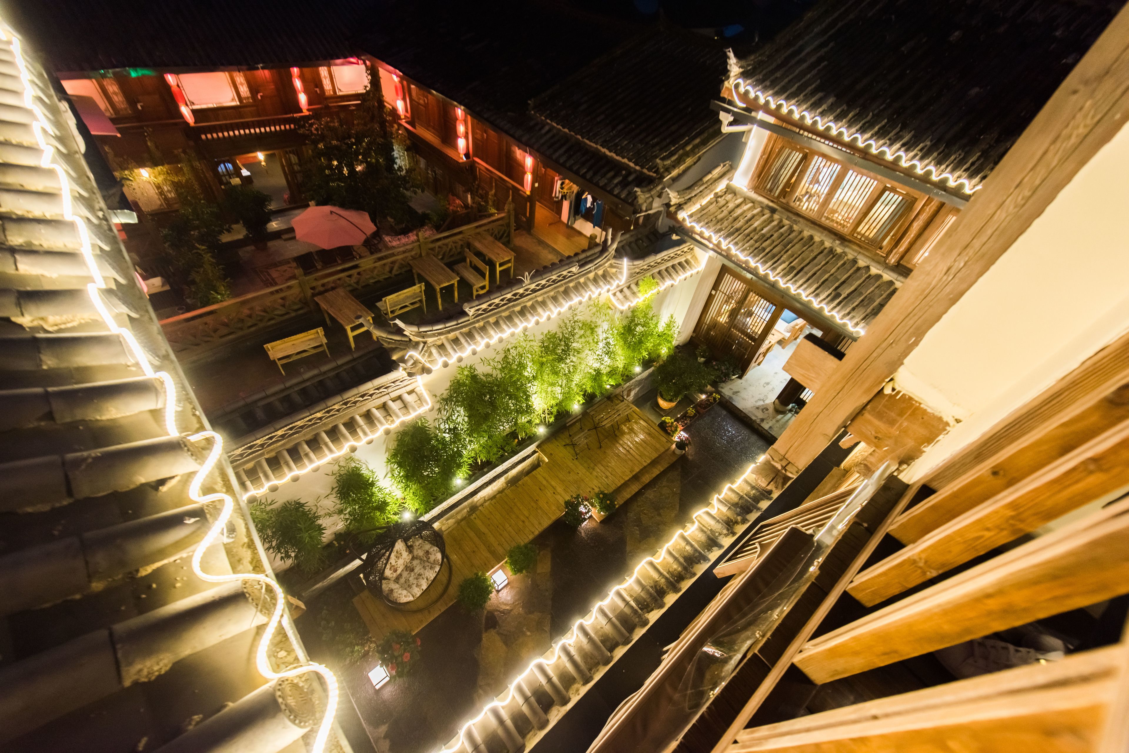 A traditional courtyard with wooden walkways and a seating area.