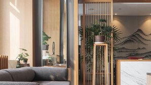 A modern lobby with a sofa, a reception desk, and a decorative wall. - Chongqing White Cloud Boutique Hotel (Chongqing)