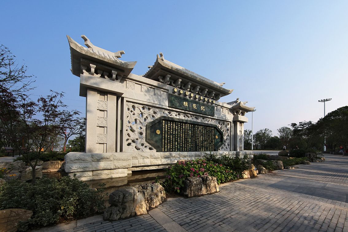 Une porte chinoise traditionnelle, ornée de sculptures complexes, avec une enseigne au-dessus.