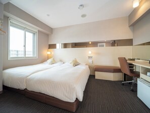 Habitación de hotel con una cama grande, un escritorio y una silla. Cuenta con una ventana que proporciona luz natural y vistas al exterior.
