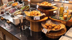 Um buffet com diversos alimentos e acompanhamentos.