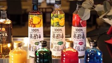 Variedad de botellas con etiquetas, algunas con imágenes de frutas y otras con texto.