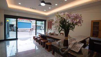 A modern reception area with a marble counter, a telephone, and a vase of flowers.